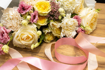 Floristry. Flowers. Multicolored bouquet of roses, carnation, tulip, soft focus. Tools and accessories for making.