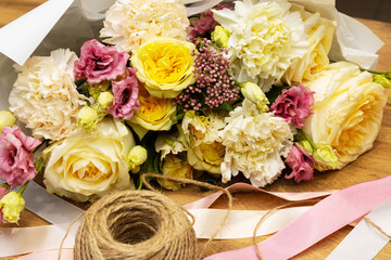Floristry. Flowers. Multicolored bouquet of roses, carnation, tulip, soft focus. Tools and accessories for making.