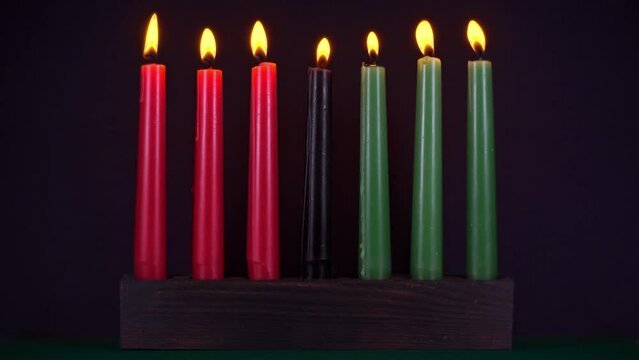 Kwanzaa festival concept with seven candles red, black and green in candlestick over black background