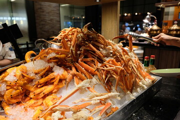 Crab. A hand holding a crab leg at a seafood buffet in Hong Kong hotel
