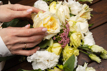 Floristry. Flowers. A florist girl collects a bouquet on the desktop, brown in color.