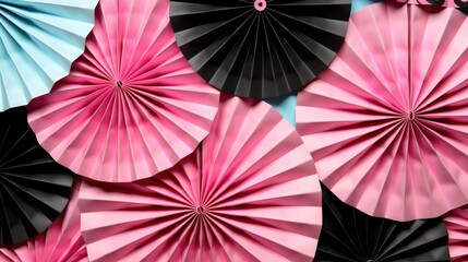 A bunch of pink and black paper fans. Birthday celebration or anniversary festive background.