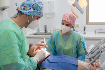 A patient undergoing a dental check-up in a clinic with the dentist in attendance and all the tools...