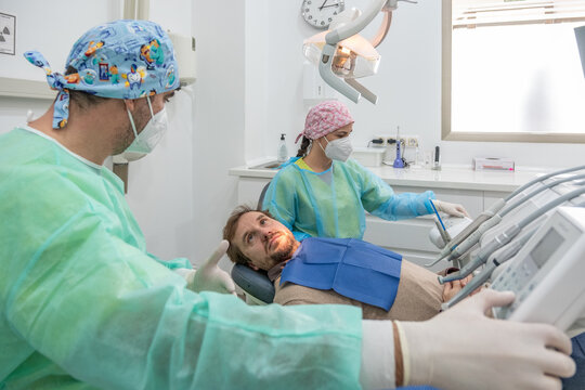 A patient undergoing a dental check-up in a clinic with the dentist in attendance and all the tools of dental care.