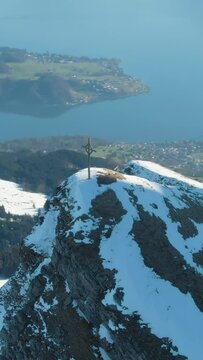 Cross on Top of Mountain and Lake Lucerne. Clear Winter Morning. Swiss Alps, Switzerland. Aerial View. Drone is Orbiting. Vertical Video