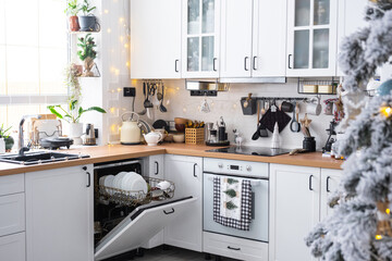 A lot of dirty dishes in the dishwasher in the festive kitchen. Helping the hostess, economy and...