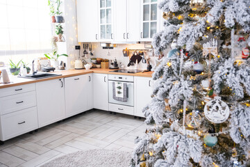 Christmas decor in white kitchen, festive mess, village interior with a snowy Christmas tree and...