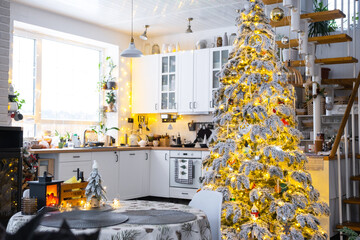 Festive Christmas decor in white kitchen, modern village interior with a snowy Christmas tree and...