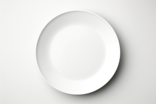 A white plate on a table with a fork and knife.