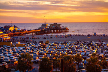 The beachfront parking lot in Santa Monica, california during sunset. Picture taken from the bluffs with the santa monica pier in the background.