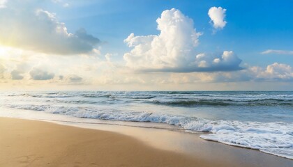 sandy beach blue cloudy sky and soft ocean wave with warm sunset light