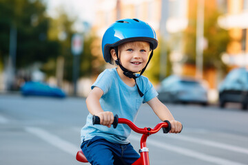 Obraz premium child riding a bike. portrait of a boy riding a bike. Happy boy in bicycle helmet riding on the road on a bicycle and screaming with happiness. Portrait. Close-up. Backpack on your shoulders