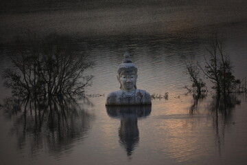 Sinking Buddha statue (Drowning Buddha) and reflection.A large Buddha statue in the middle of the lake. Phre Phutta Siri Phuwadon Mongkolchai.
Khao Ra-Kham reservoir, Trat province,Thailand.