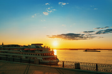 Cruising along the river. Cruise liner on the quay at the embankment. Romantic sunset on the Volga...