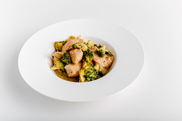 Vindaloo with spinach in white bowl isolated on white background. Portuguese Influenced Indian dish made by cooking chicken in vindaloo spice paste and broccolli.