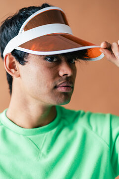 Man in green sweater with visor cap smiling widely