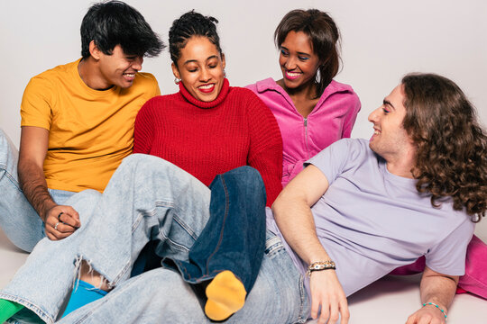 Group of four friends casually lounging together, exuding warmth and relaxation
