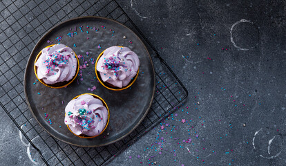 Festive chocolate cupcakes with lilac cream cheese on grey background copy space for text