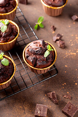Chocolate brownie muffins with mint on dark background, vertical photo
