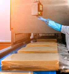 Two workers start making blocks of cheese in a factory.