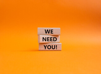 We need you symbol. Concept words We need you on wooden blocks. Beautiful orange background. Business and We need you concept. Copy space.