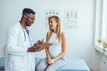 Doctor discussing treatment with cheerful smiley female patient. Happy physician and young man...