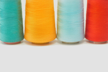 Three spools of thread. Emerald, red, blue, yellow