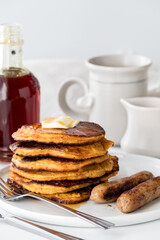 A stack of sweet potato pancakes with sausages, ready for eating.