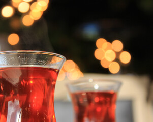 Black Turkish tea in thin glass cup for two, prepared for breakfast in sunny, luxurious restaurant....