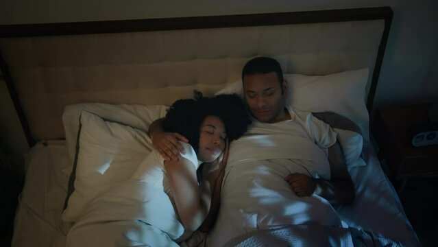 Calm tranquil night at home bedroom sleeping African American couple family boyfriend girlfriend wife husband woman man relaxed sleep napping together hugging at nighttime love orthopedic mattress