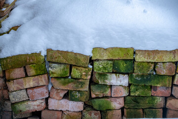 old clay bricks from demolished house under snow blanket