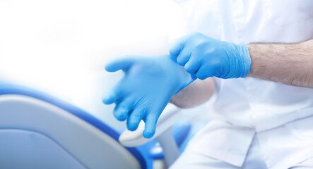 Banner dentistry, professional dentist puts on blue medical gloves in dental office