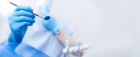 Dentistry clinic banner with copy space. Dentist using equipment mirror for examination of teeth of...