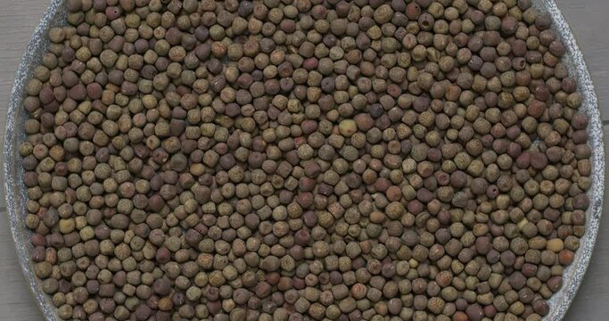 Top view of dried whole Nepali peas (saano kerau) on a plate. Table spin.