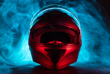 Modern motorcycle helmet on the shop counter in the smoke in the neon lights background.