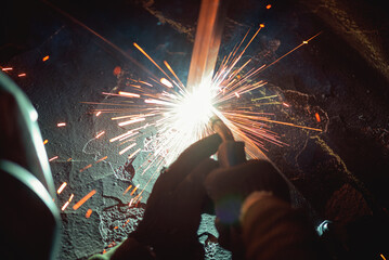 Welder is welding a metal pipes by semi automatic welding.
