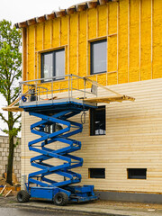 Facade cladding works with wooden planks after facade spraying with thermal insulation foam