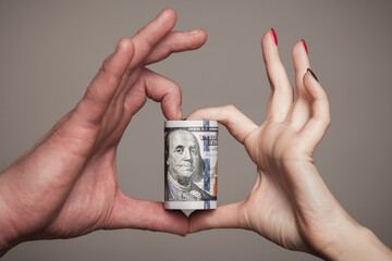 Everyone loves money. Male and female hands holding money and making together heart gesture.