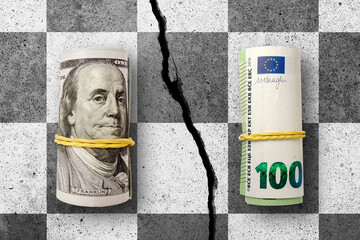 100 US dollars and 100 Euros banknotes on cracked concrete chess desk. Euro and Dollar exchange...