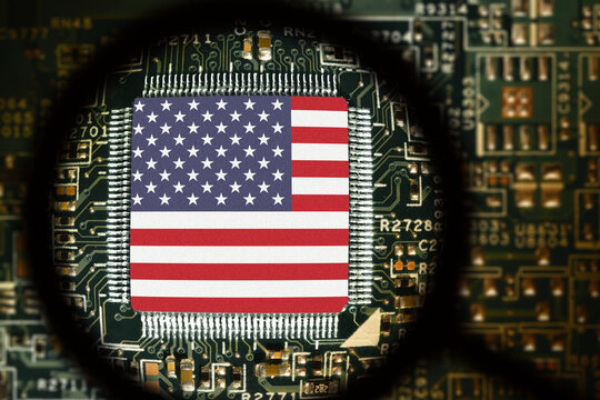 Flag of United States of America on a processor. Computer board with chip. View through magnifying glass