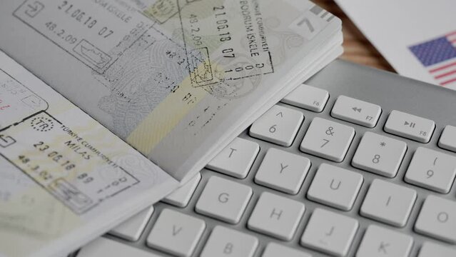 Ukrainian passport with visa stamps and euro banknotes, US migration documents and keyboard. Passport and migration creative advertising concept. Close up of identity document.