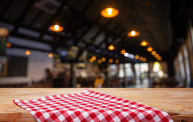 Empty wooden deck table and red checked tablecloth over mint wallpaper background. High quality photo