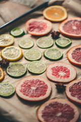 Sliced orange, tangerine and grapefruit slices on baking sheet, preparing citrus wedges for Christmas garland