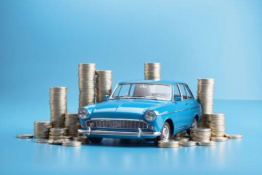 saving for a vintage car: a blue car on gold coins with a blue background, investment and insurance concept
