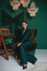 Fashionable smiling woman wearing elegant green suit in studio