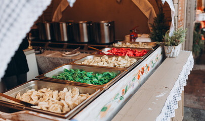 Dumplings on display in a christmas setting at a holiday market. Festival of street food. Selling traditional hot food at the Christmas Fair