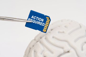 A man inserts a memory card into his brain with the inscription - Action Required