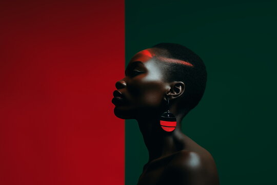 Close up of a young black woman with face paint in red color and earing. African woman on red and green background with copy space for text. Black History Month concept.