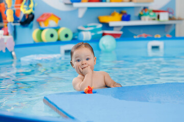 Concept healthcare sport for infant. Portrait Cute happy laughing baby girl swimming in pool, teaching small swimmer