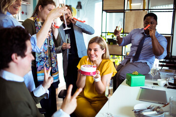 Smiling young woman celebrating birthday in office